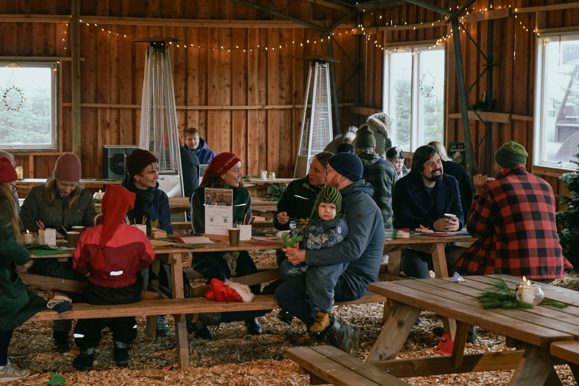 Gæster hygger ved langbordene i Café Træladen